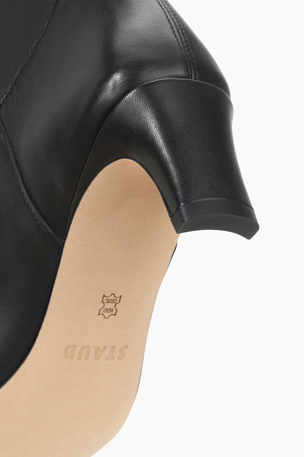 Black leather boot heel and side seam with small embossed logo on insole