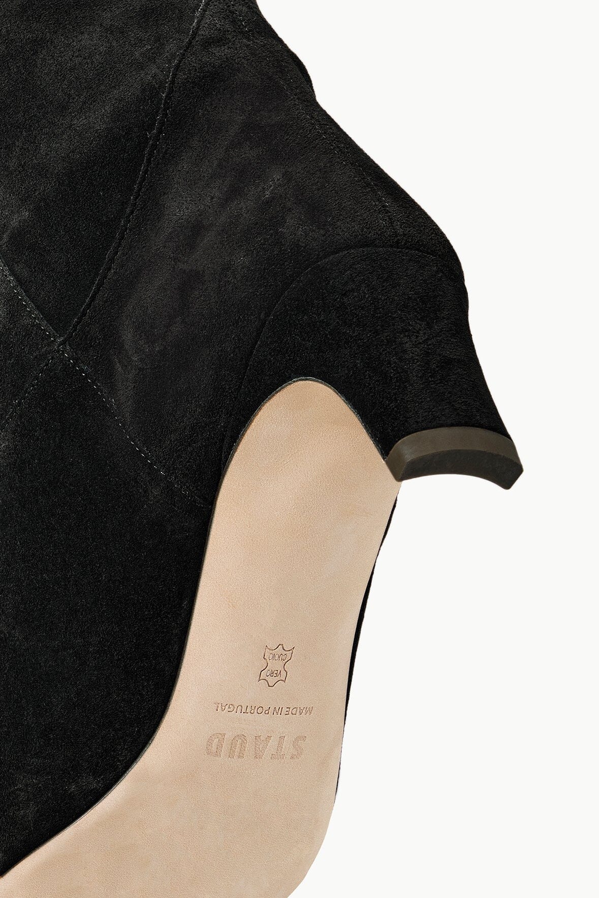 Black suede boot upper close-up with tan insole and heel detail