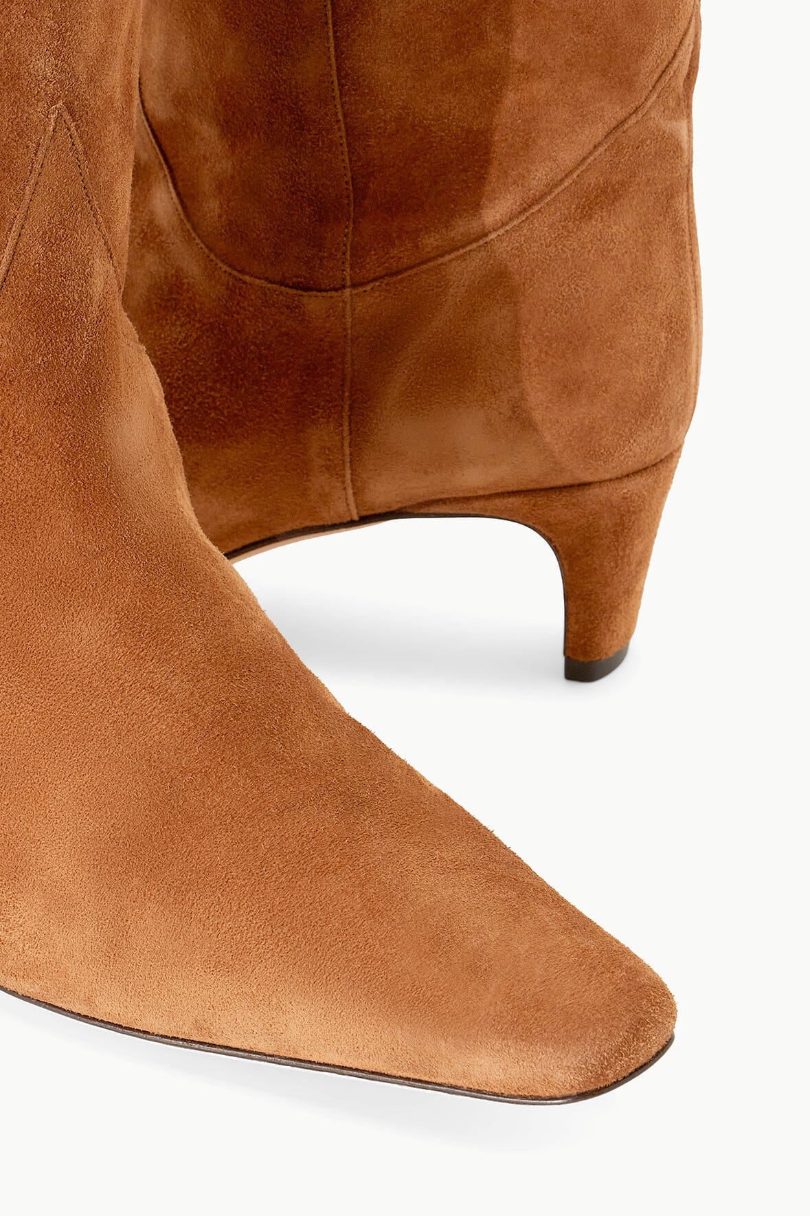 Tan suede western boot with curved quarter seam and low stacked heel