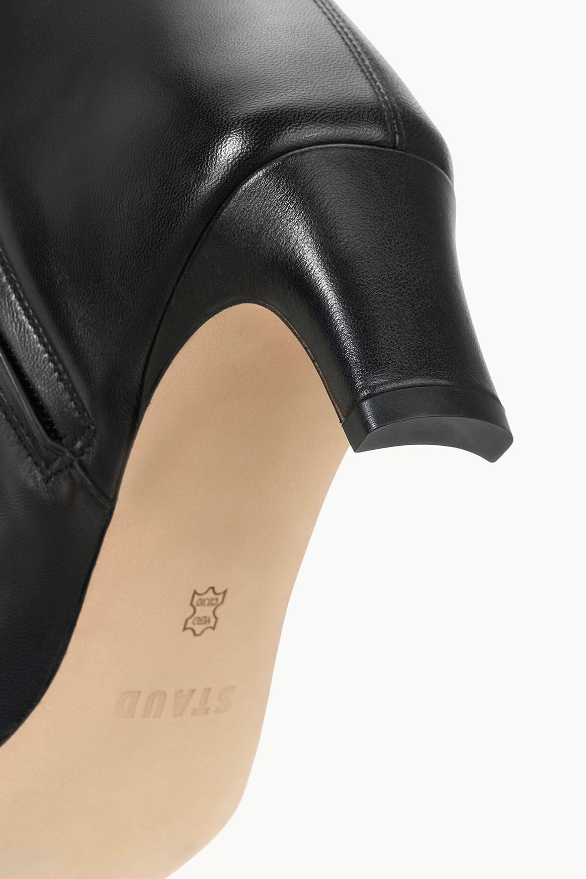 Black leather boot close-up showing inner heel area and small logo stamp