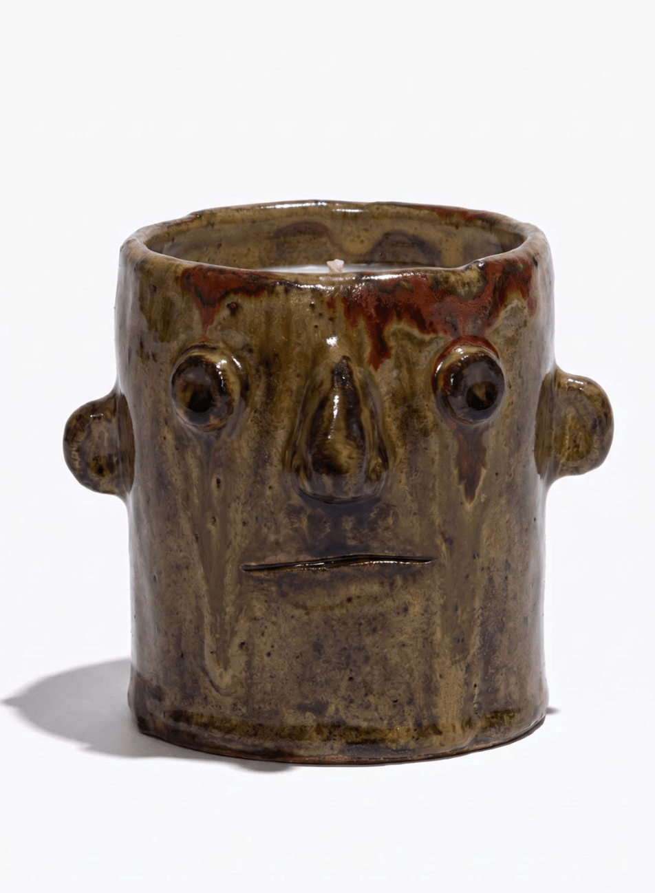 Green-brown ceramic candle holder with face motif, side knobs, open top