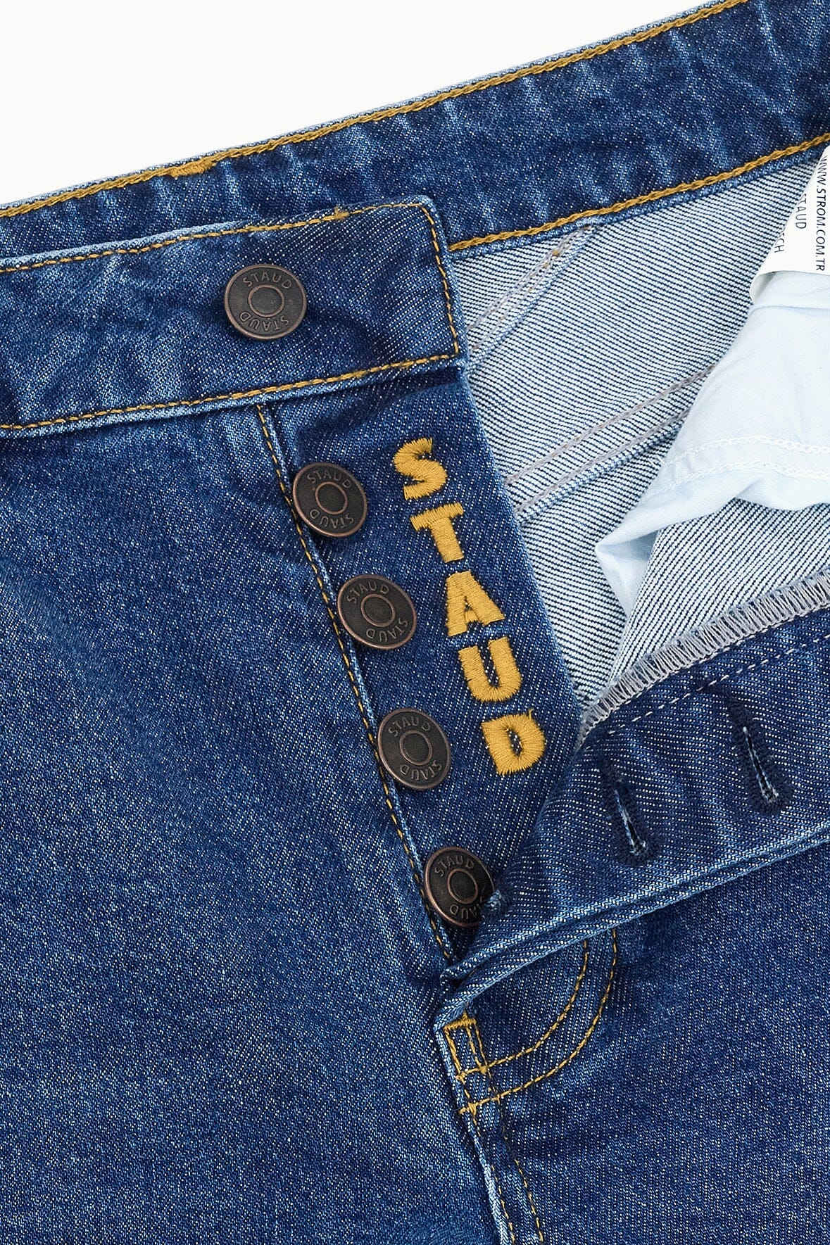 Stone blue denim jeans close-up of button fly and front pocket