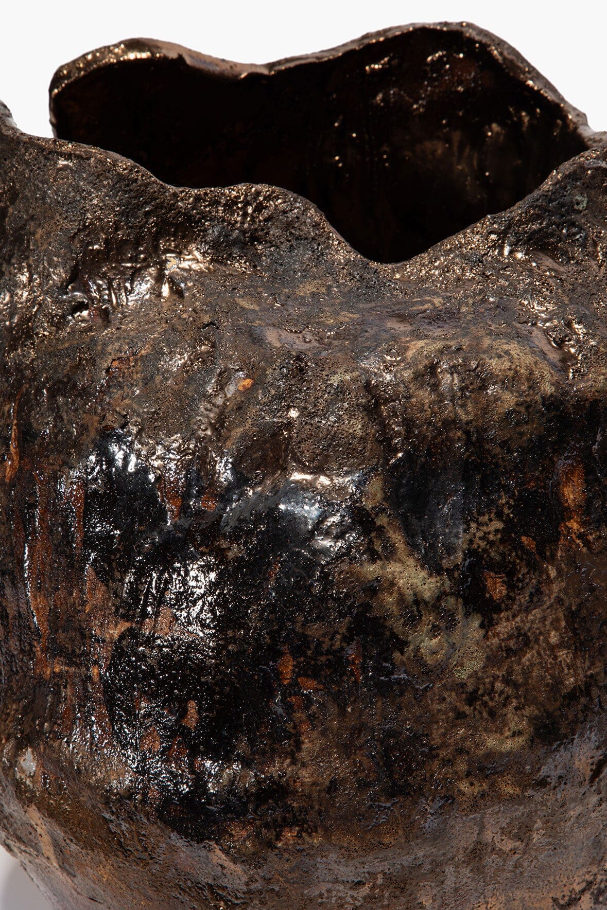Textured ceramic vase close-up, dark speckled glaze with glossy highlights and open rim