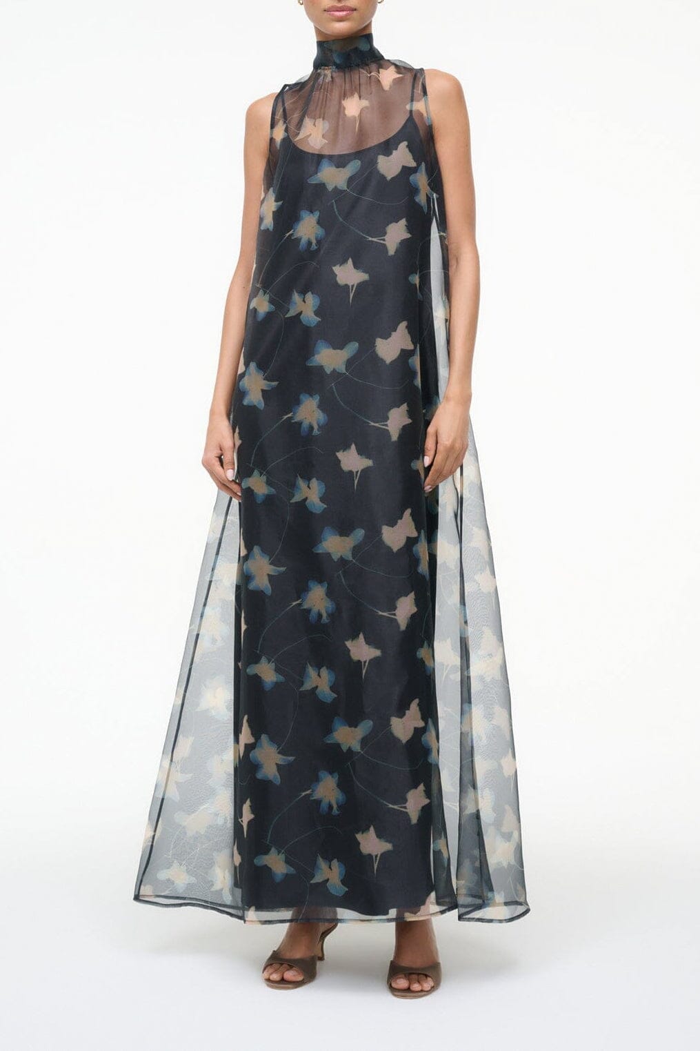 Sheer black botanical print maxi dress with sleeveless high neck and flowing skirt