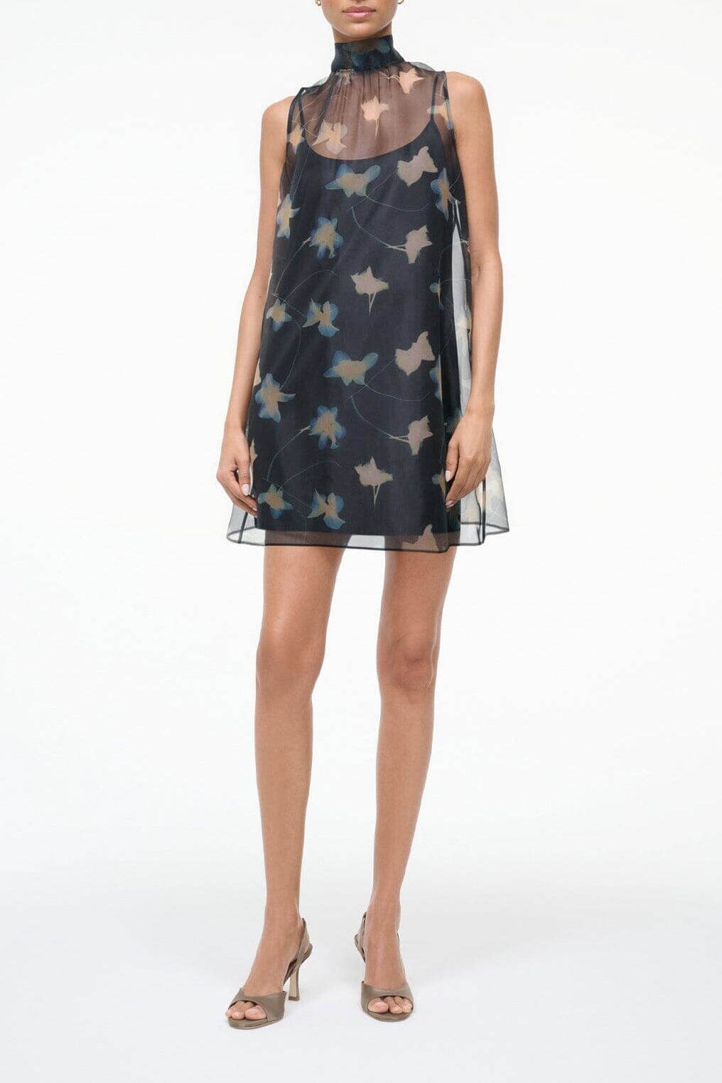 Dark sleeveless mini dress with high neck and sheer mesh layer, botanical print