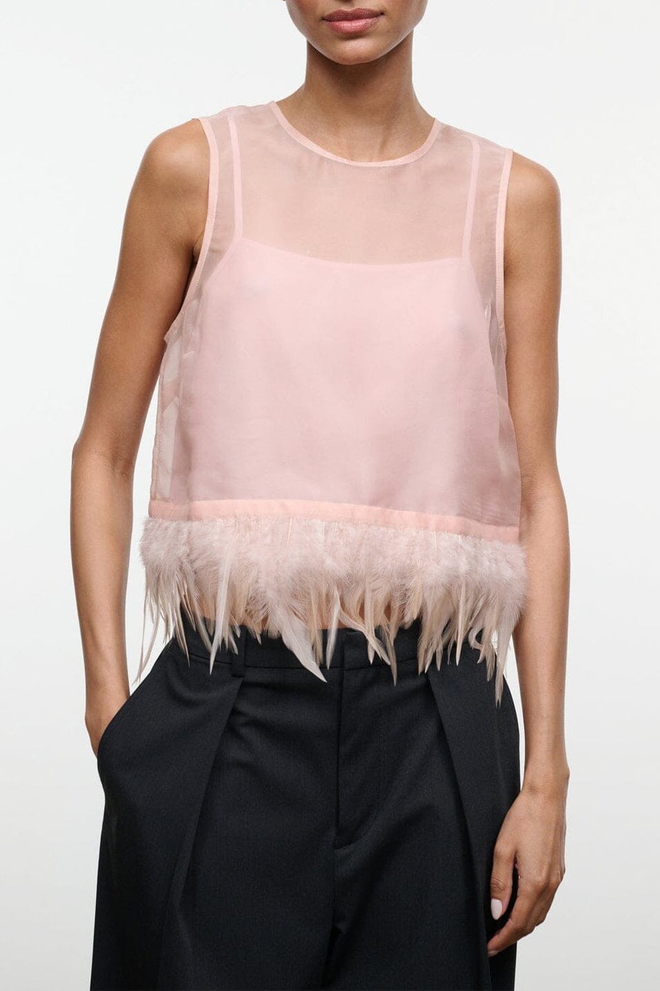Sheer pink sleeveless camisole top with round neck and feather fringe hem