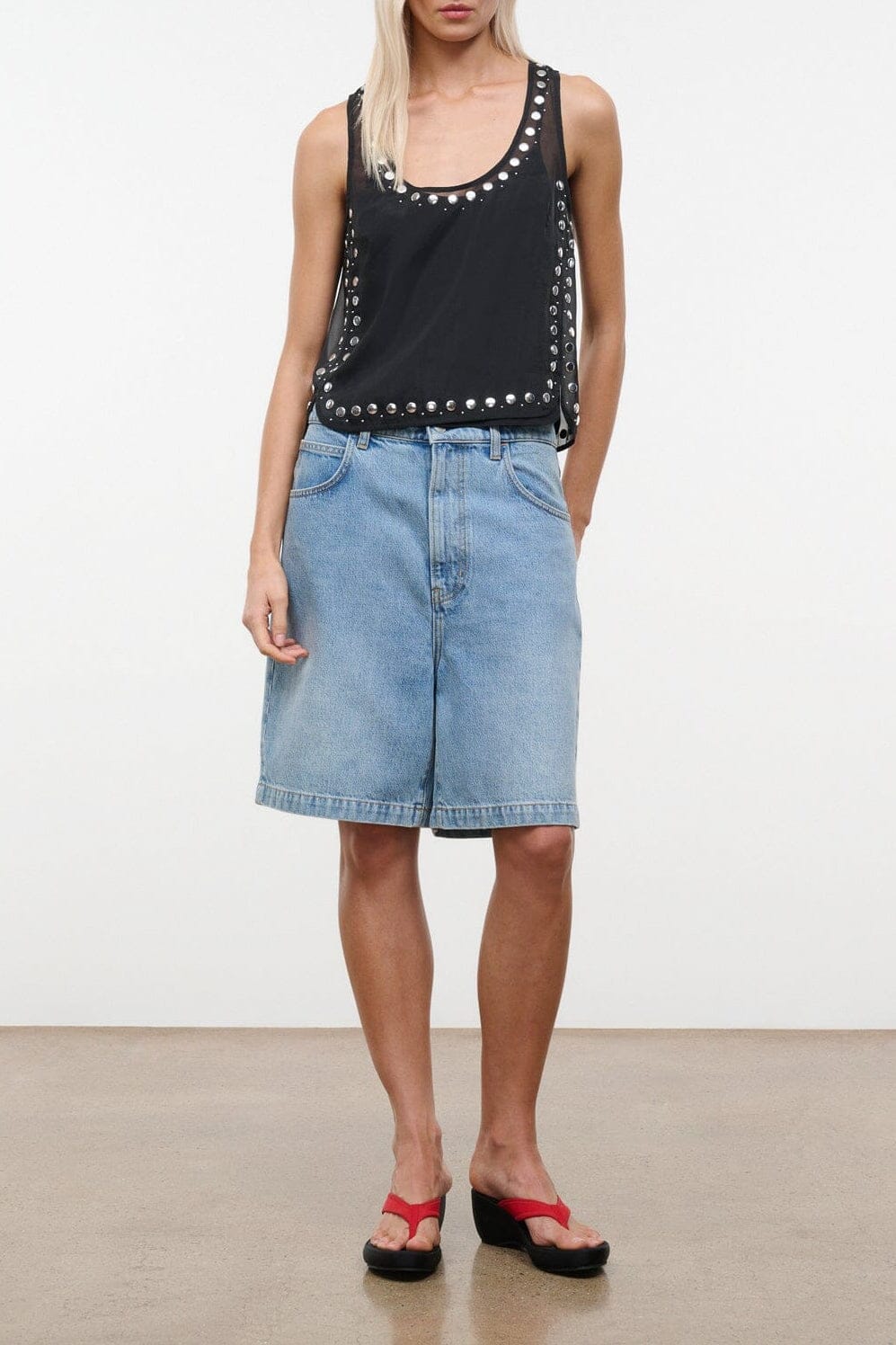 Black sleeveless top with studded neckline and front trim