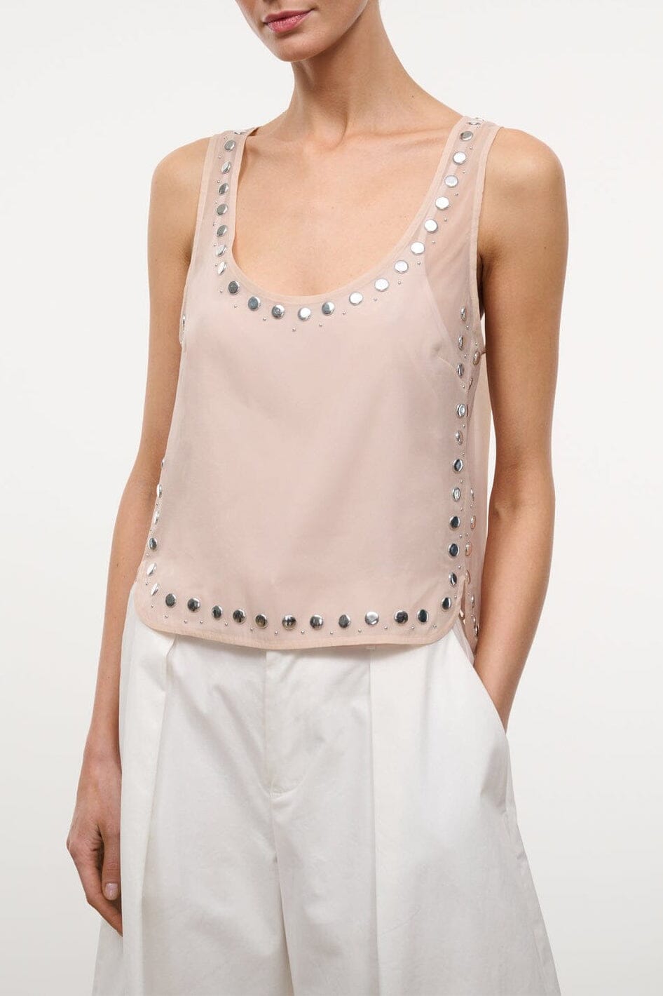 Sleeveless studded tank top with scoop neckline and silver studs, light beige