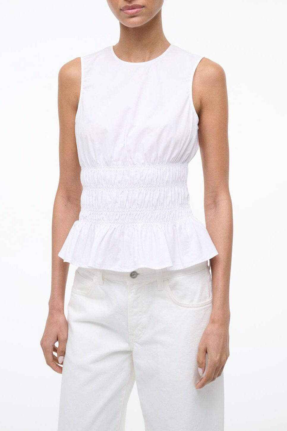 White sleeveless peplum top with gathered waist and ruffled hem