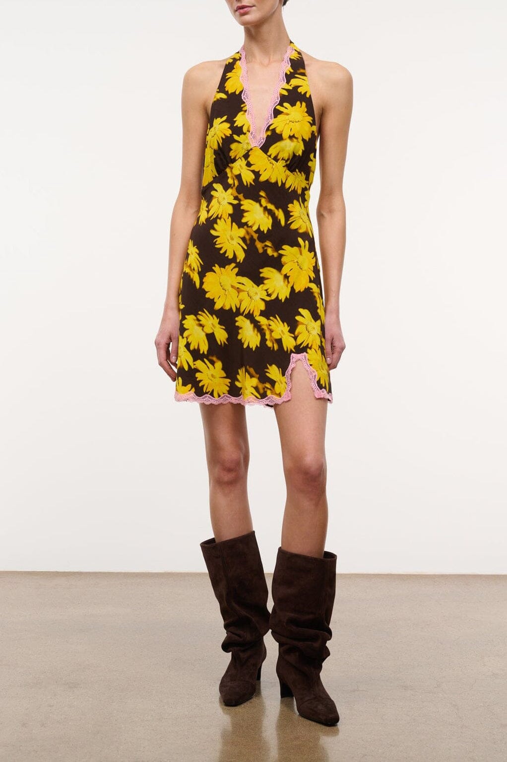Black mini halter dress with yellow daisy floral print, sleeveless V-neck.