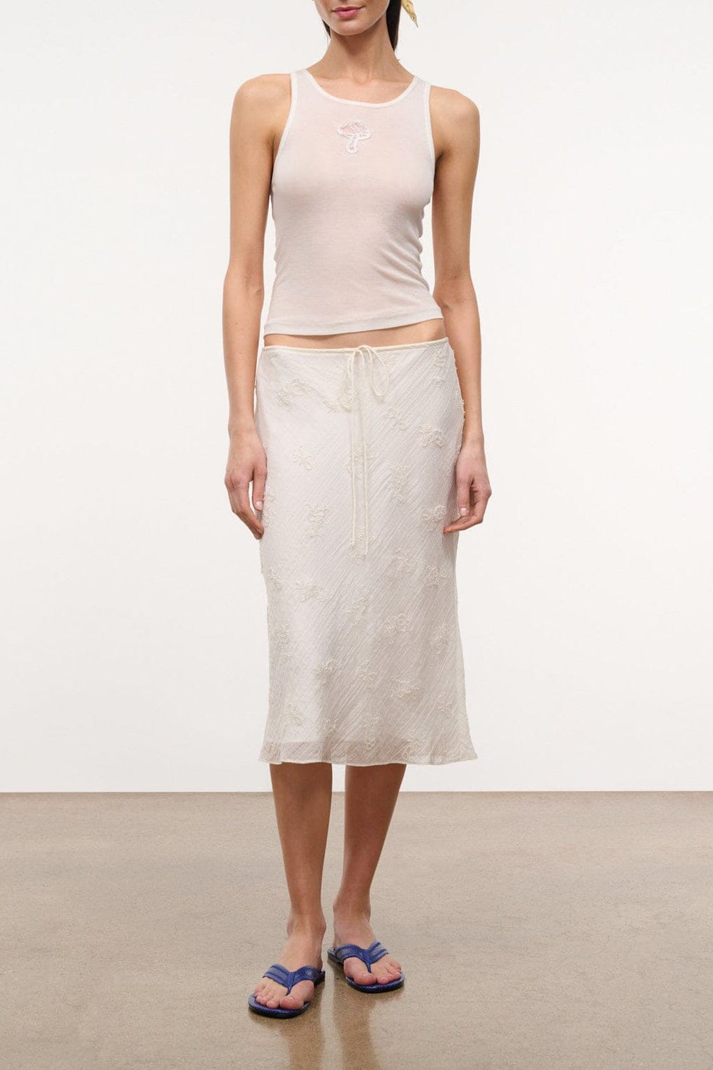 Ivory sleeveless tank top with scoop neckline and racerback seams