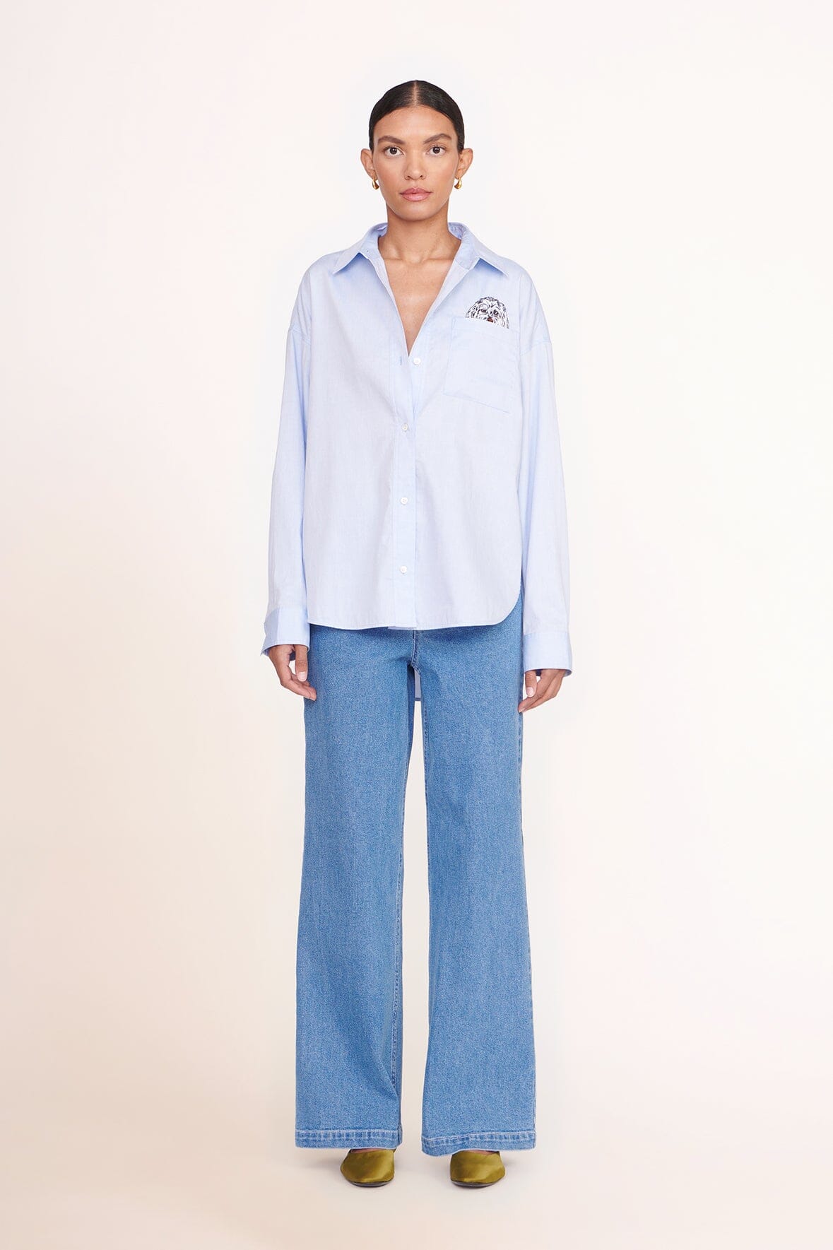 Light blue oversized button-up shirt with pointed collar and chest logo patch