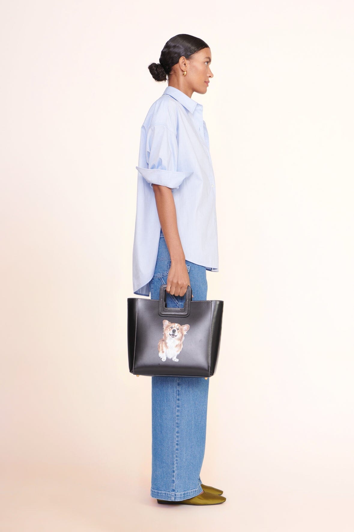 Light blue oversized button-up shirt shown in side profile with pointed collar and logo patch