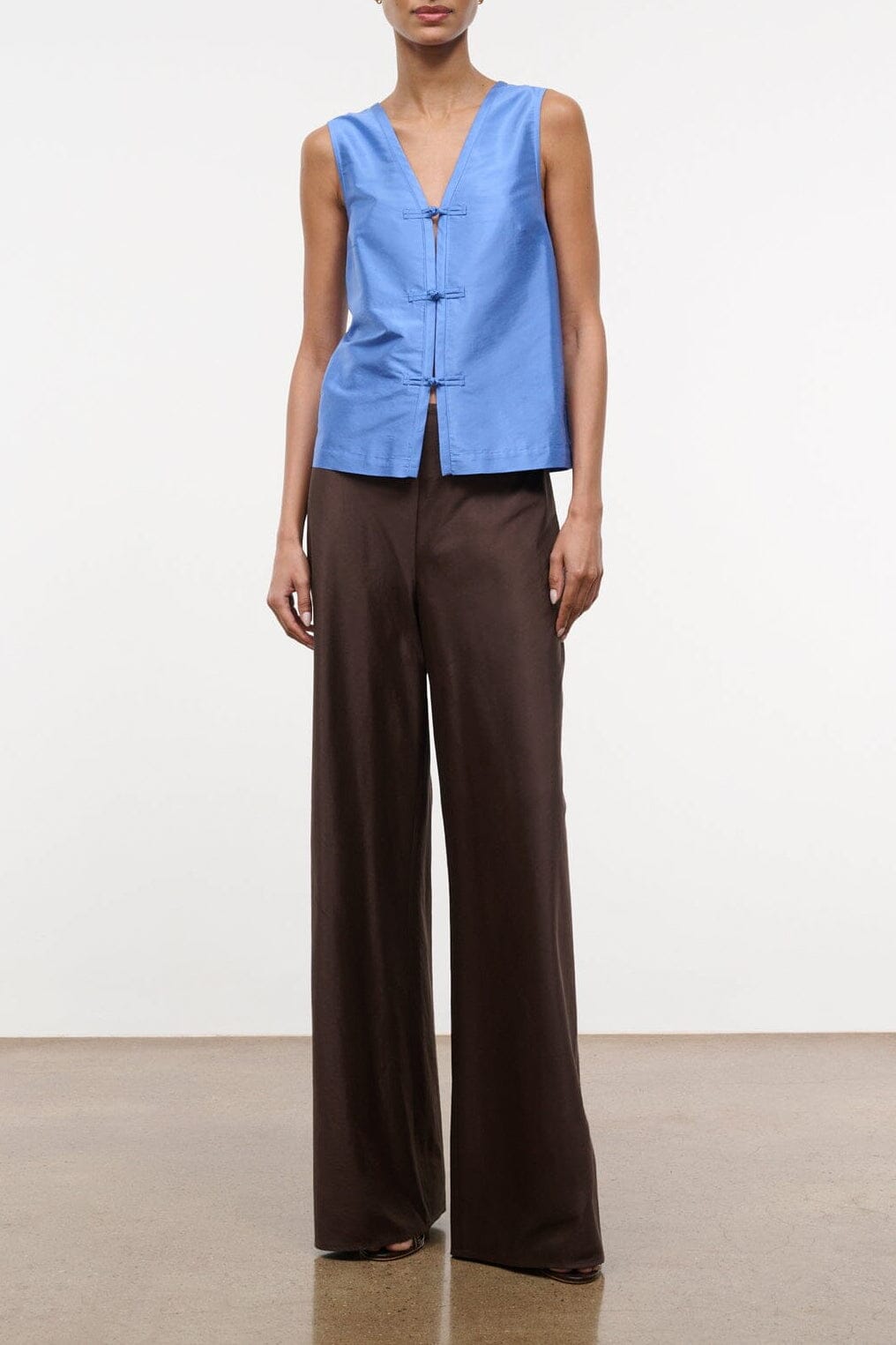 Light blue sleeveless silk dupioni top with V-neck and front button placket