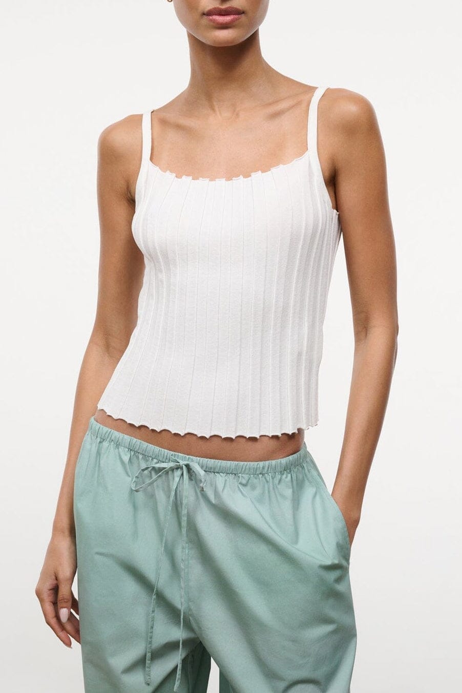 Ivory sleeveless tank top with ruffled neckline and scalloped hem