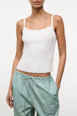 Ivory sleeveless tank top with ruffled neckline and scalloped hem