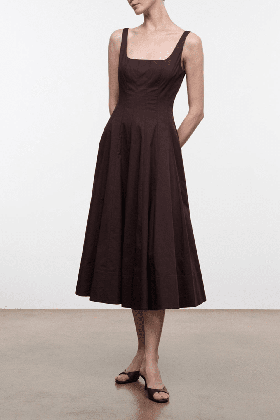 Dark brown sleeveless midi dress with square neckline and pleated, swingy skirt